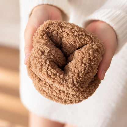 Nahaufnahme einer Hand, die eine Haussocke hält, das camelfarbene Teddyfutter im Inneren ist zu sehen